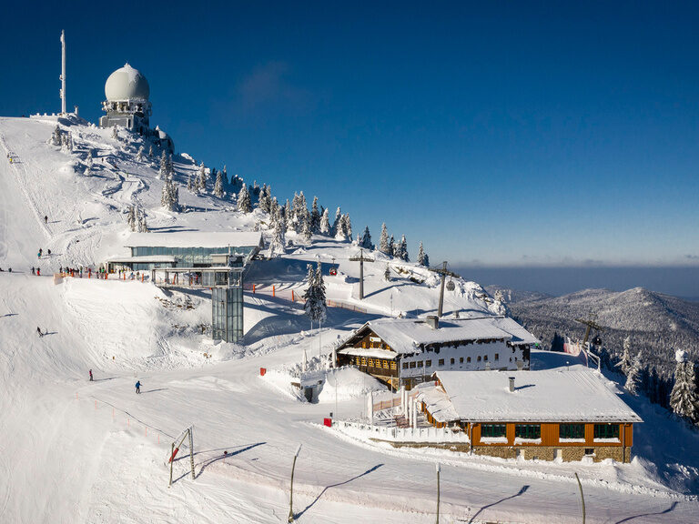 Der schneebedeckte Abergipfel mit Wetterstation und verschiedenen Gebäuden.